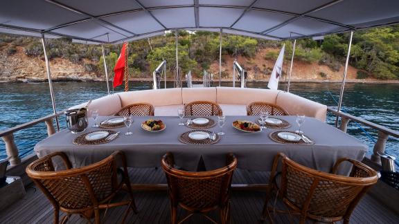 Elegantly set dining table on Gulet Pronto White, perfect for an outdoor dinner with a view of the tranquil coast.