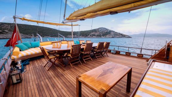 Das elegante Deck der Bodrum-Gulet Flas VII mit komfortablen Sitzbereichen und Essplätzen, perfekt für entspannte Abende