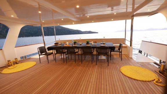 Spacious dining area of the trawler Nayk 3 anchored in Göcek, with comfortable chairs and a sea view.