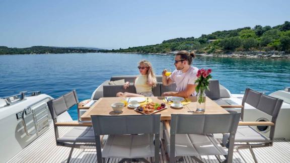 Couple having breakfast on the aft deck of motor yacht Simull.