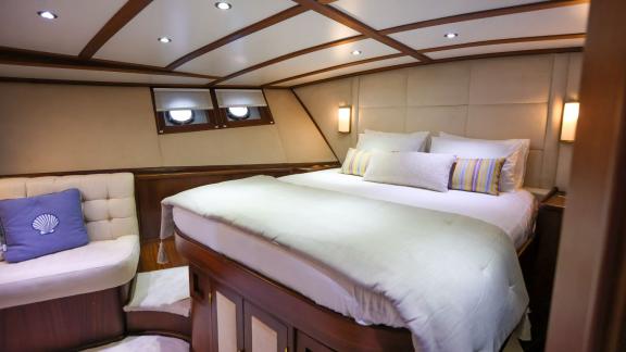 Gazella’s guest cabin features a large bed, a comfortable seating area, and wooden details.