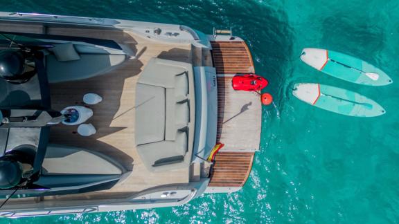 The aft deck of motor yacht Chilli is seen with water toys in the sea.