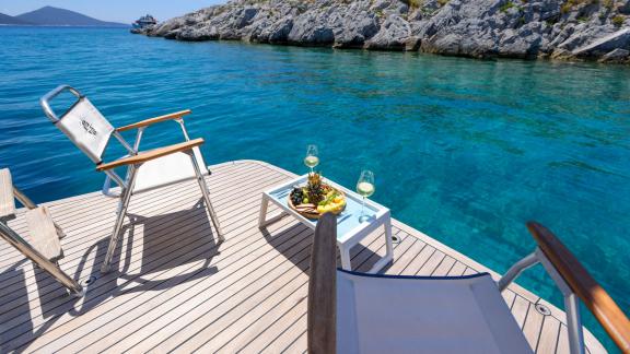 Gazella’s swim platform features loungers, a fruit plate, and wine glasses.