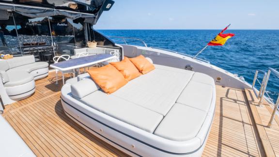 The aft deck of motor yacht Five Stars features a spacious sunbathing area and a dining table.