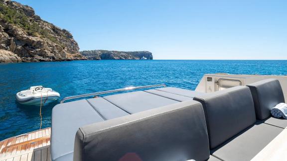 Graue Liegefläche auf dem Achterdeck der Motoryacht Petitchet mit Blick auf das offene Meer.