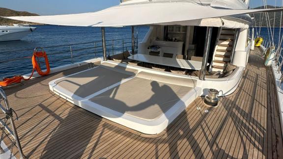 The aft deck of Angelo 3 features large loungers and a shaded seating area.