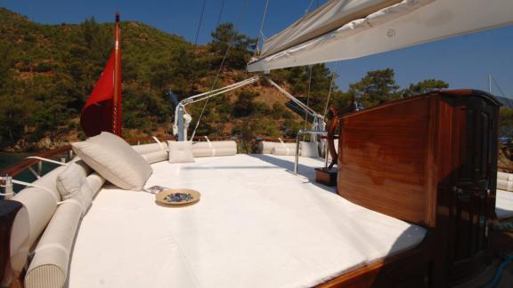 Deck with comfortable cushions and view of wooded coast