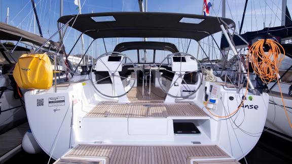 The cockpit of the yacht Anse, featuring dual helms and a spacious seating area, anchored in the marina.