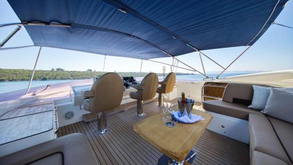 The helm of the motor yacht Agave with luxurious seating and a shaded canopy.