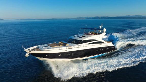 The motor yacht Agave cruising at high speed over the open sea under a clear sky.