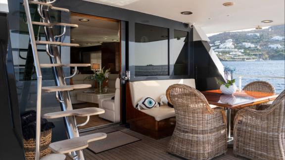 Shiva features an aft deck dining area for daily motor yacht charters and private sea tours in Mykonos.