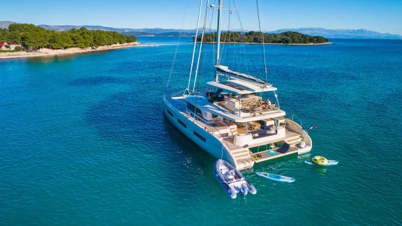 Luxurious Amada Mia catamaran anchored in a picturesque bay, surrounded by crystal-clear waters