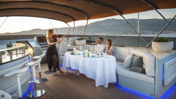 Romantic dinner for a couple with violin accompaniment on the upper deck of the motor yacht Anavi.