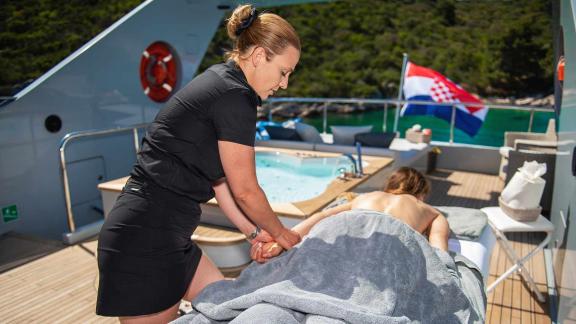 Relaxing spa massage on the deck of the motor yacht Anavi by a therapist.