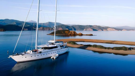 Die Motorsailer-Yacht Angelo 2 liegt in einer ruhigen Bucht vor den Yassica-Inseln vor Anker.