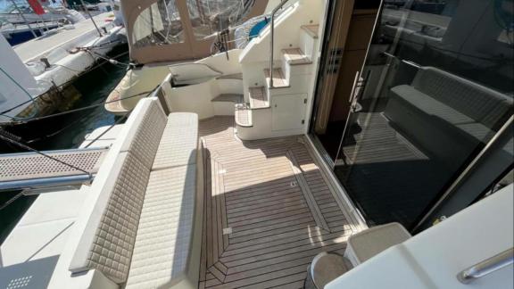 Among Saint Tropez yacht charter options Escapade motor yacht shows aft deck bench seating and stair access.