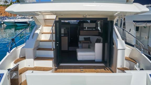 Among Saint Tropez yacht charter options Escapade motor yacht shows aft deck seating and interior entrance.