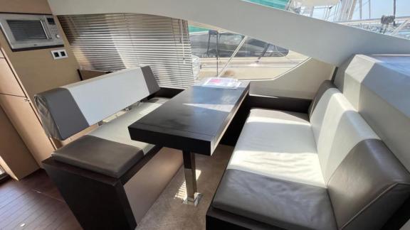 Among Saint Tropez yacht charter options Escapade motor yacht shows interior with opposite seating and table.