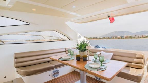 Auf dem Heckdeck der Motoryacht Aron 26 befinden sich ein Esstisch und gemütliche Sitzplätze.