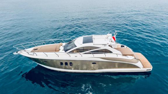 Aron 26 motoryatı, açık kahverengi gövdesiyle Mykonos açıklarında su üstünde duruyor.