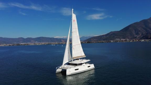 The Reina 1 catamaran offers a smooth journey with its large sails on calm waters.