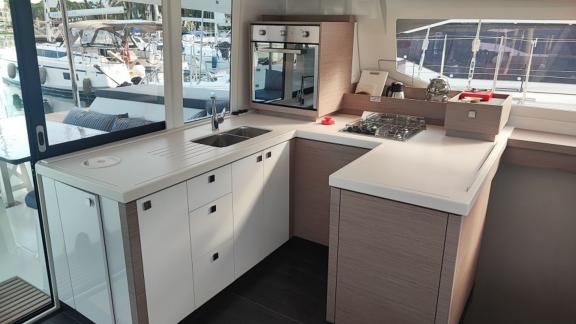 The modern kitchen of the Reina 1 catamaran features spacious countertops and fully equipped cooking facilities.