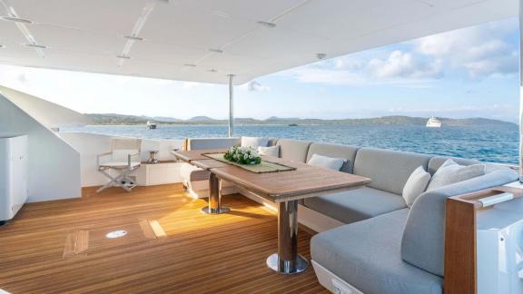 Comfortable seating and dining area on Nemesis motor yacht aft deck.