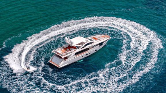 Motor yacht Nemesis anchored near Mallorca, a boat rapidly circling around it.
