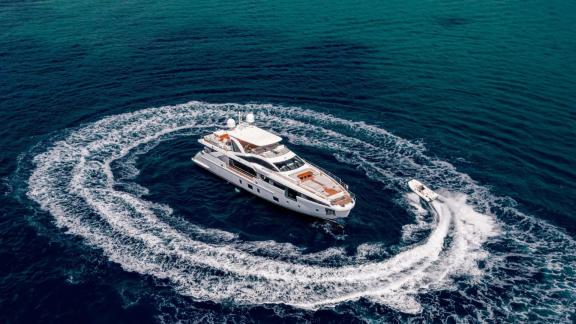 Motor yacht Nemesis anchored near Mallorca, a boat making fast circles around it.
