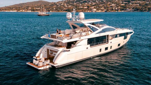 Nemesis anchored near Mallorca. Upper deck with comfortable seating. Comfortable yacht rental option.