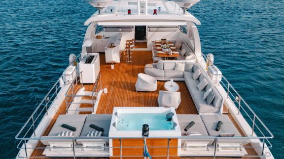 The upper deck of motor yacht Nemesis features a spacious seating area with comfortable lounge spots.