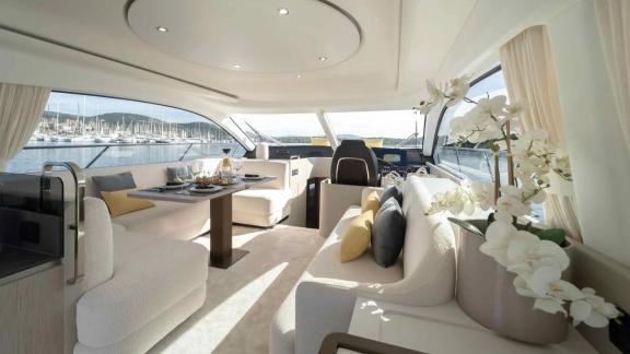 Comfortable sofas, dining table, and marina views inside Leeloo’s stylish salon.