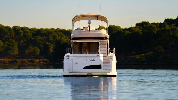 In Sibenik motor yacht charter option Nalu rear view on calm sea with modern design offering smooth and comfortable crui