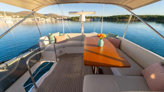 In Sibenik motor yacht charter option Nalu upper deck with dining table and sea view offering enjoyable moments visible.
