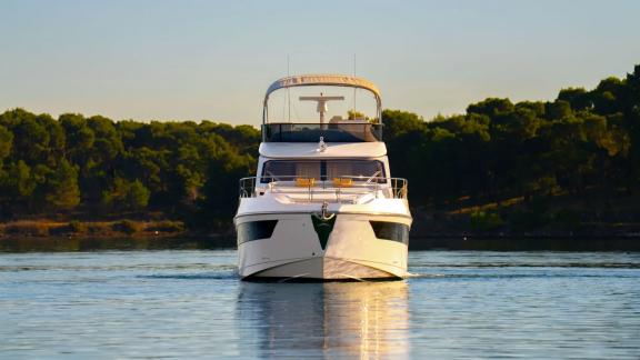 In Sibenik motor yacht charter option Nalu front view on calm sea with modern design offering smooth and comfortable cru