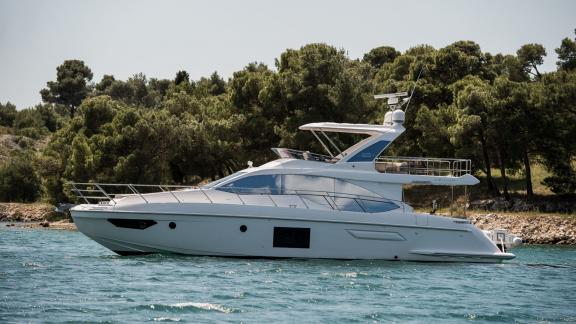 Die Mawi ruht in klarem Wasser vor grüner Küste. Ideal für entspannte Yachtcharter.
