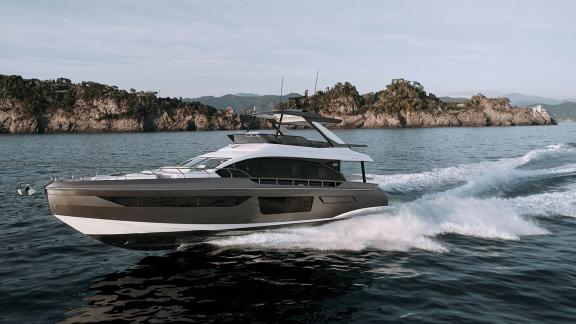 Die moderne Pangea Yacht gleitet über die Wellen mit Blick auf Küste und Flybridge.