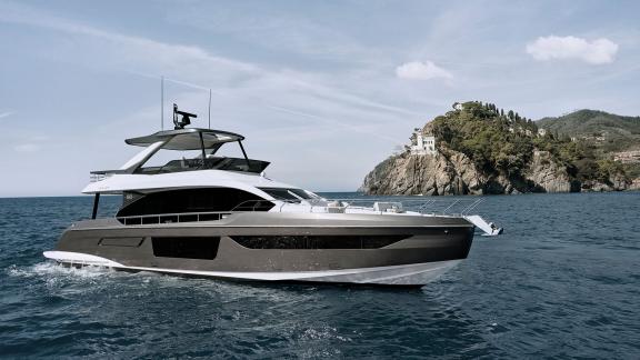 Die Pangea Yacht mit großem Vordeck und Flybridge fährt entlang der Küstenlandschaft.