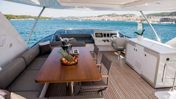 Обеденная зона на флайбридже моторной яхты Azimut 72 Alyss у побережья Сплита с видом на море.