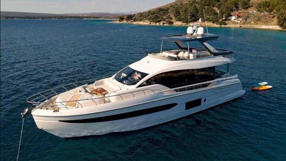 Omr Group liegt in einer Bucht bei Split. Zu sehen sind Bug Lounge und ein Board im Wasser.