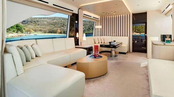 Moderne Sofas und große Fenster schaffen eine helle Atmosphäre mit Meerblick.