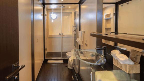 The Jungle motor yacht in Ibiza features a glass shower cabin, sink unit and private bathroom area.