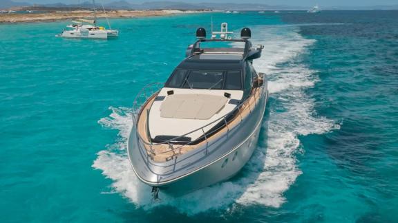 The Jungle motor yacht is cruising off Ibiza, showcasing its sleek design across turquoise waters.