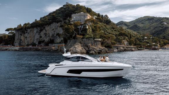 Discovery Bay motor yacht is cruising along the Monaco coast offering a luxury yacht charter experience.