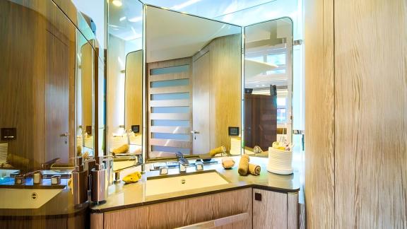 Holzdetails und großer Spiegel sorgen für elegantes und funktionales Ambiente.