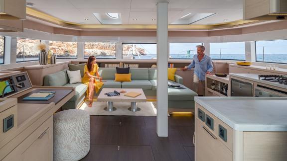 Two people relaxing in the stylish and bright salon of the Lagoon 55 catamaran with panoramic views.