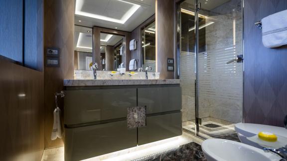 Guest bathroom on the Opari yacht with double sinks, elegant lighting, and modern decor.