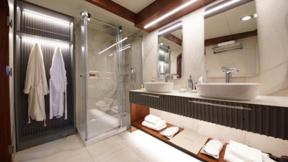 Bathroom with two sinks, large shower, and elegant lighting on a yacht