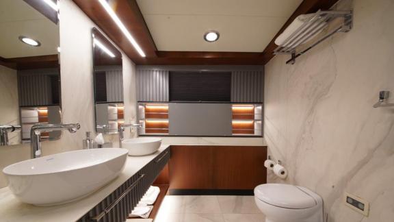 Bathroom with two sinks, marble decor, and stylish lighting on a yacht