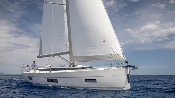 Sailing yacht Blue Monkey gliding on the sea with wind-filled sails.